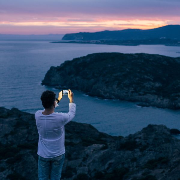 man makes photo of epic landscape sunset